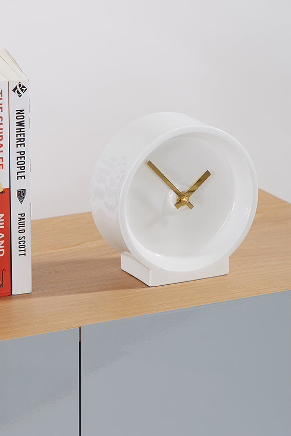 Ceramic desk clock, white, gold hands, on cabinet