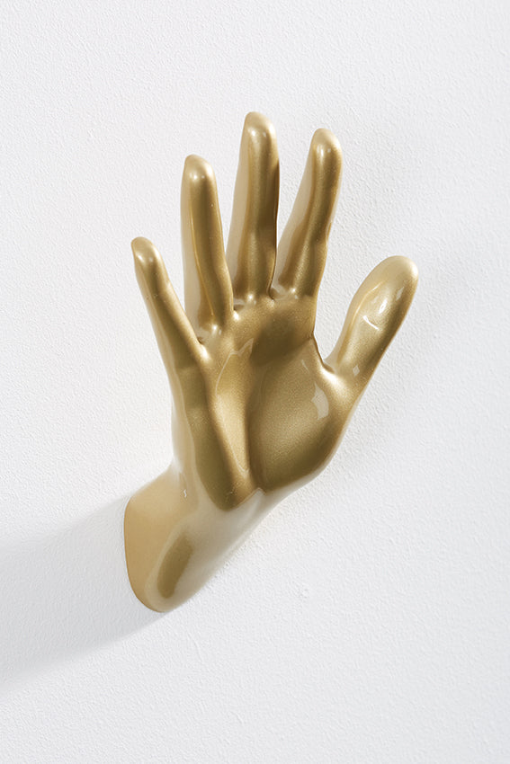 Hand wall art or hook, waving gesture, and gold colour
